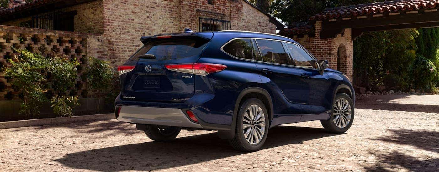 A blue 2023 Toyota Highlander Hybrid Platinum is shown from the rear parked.