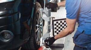 A mechanic is shown performing a tire alignment at a Toyota service center near Joliet, IL.