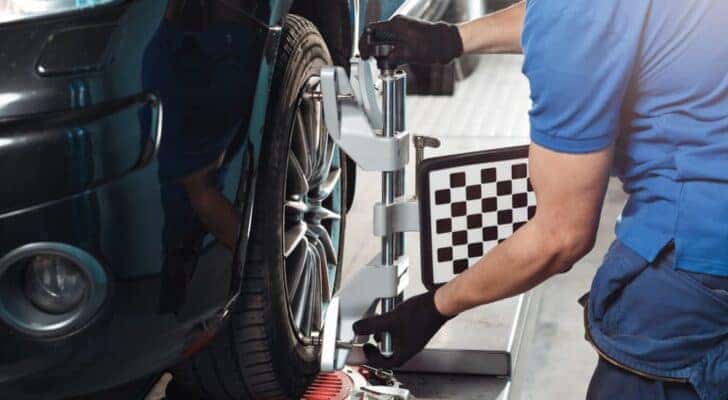 A mechanic is shown performing a tire alignment at a Toyota service center near Joliet, IL.
