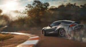 A silver 2023 Toyota GR Supra is shown on a race track.