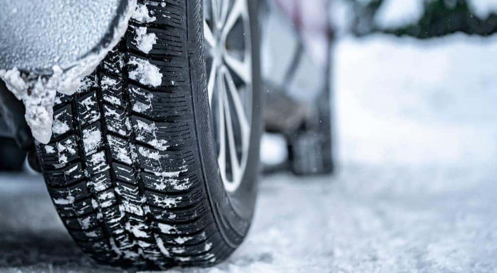 A winter tire is shown parked on snow.