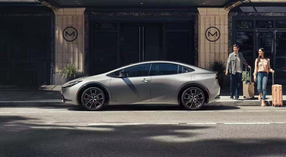 A grey 2023 Toyota Prius is shown from the side on a city street.