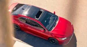 A red 2023 Toyota Camry XSE is shown from above.