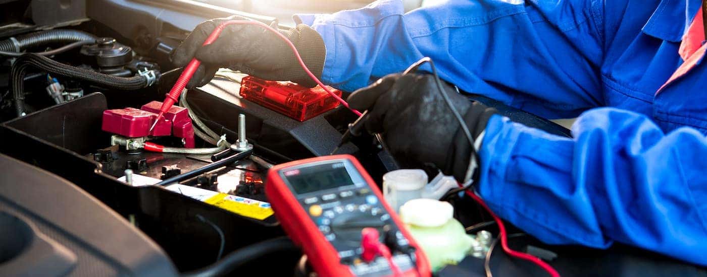 A mechanic is shown testing a car battery.