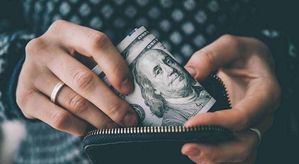 A person is shown holding cash are a battery replacement near you.