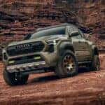 A green 2024 Toyota Tacoma Trailhunter is shown off-road.