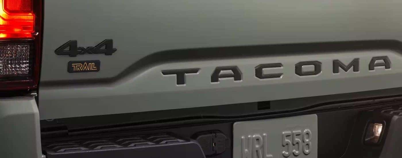 The rear badging is shown on a green 2023 Toyota Tacoma SR5 Trail Edition.