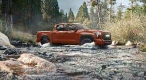 A maroon 2024 Toyota Tundra TRD Pro is shown driving through a creek.