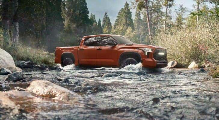 A maroon 2024 Toyota Tundra TRD Pro is shown driving through a creek.