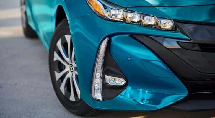 A close up of the front of a blue 2022 Toyota Prius Prime is shown at a Toyota body shop.