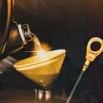 Oil is shown being poured into a yellow funnel during a Toyota oil change.