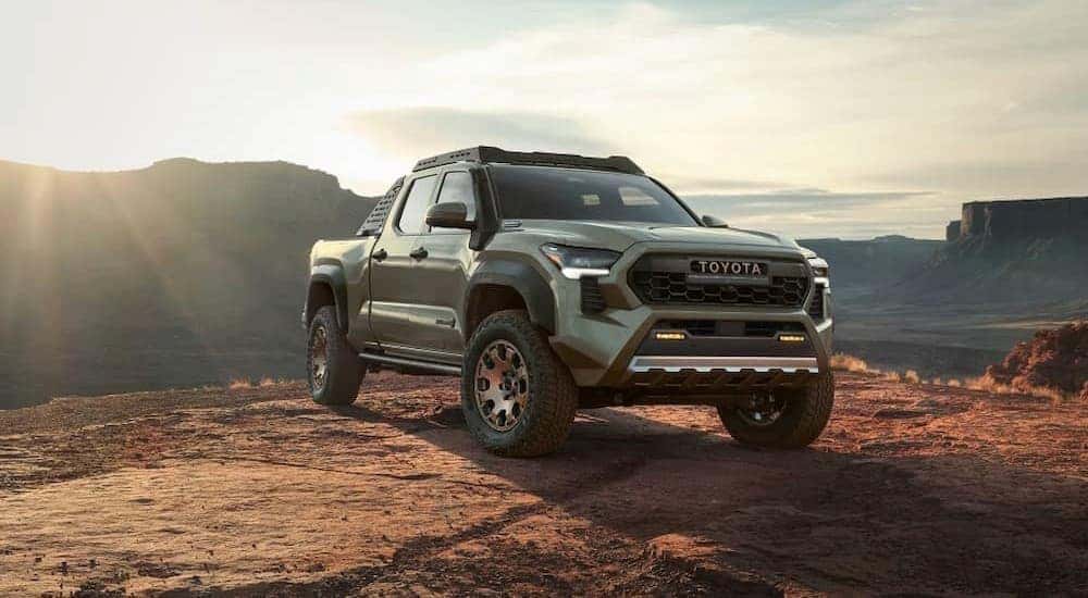 A green 2024 Toyota Tacoma is shown parked off-road after visiting a Toyota Tacoma dealer.