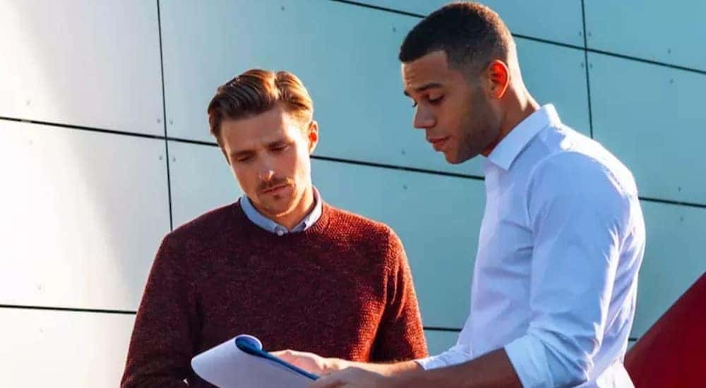 Two people are shown looking at a clipboard detailing service financing.