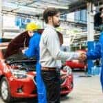 A mechanic is shown shaking hands with a customer at a Toyota service center.