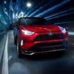 A popular Toyota RAV4 for sale near Bolingbrook, a red 2024 Toyota RAV4 Prime, is shown driving through a tunnel.