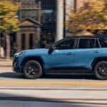 A blue 2024 Toyota RAV4 Hybrid is shown driving to visit a Toyota dealer near Orland Park.