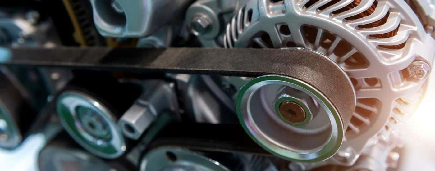 A close-up of an alternator and belt is shown.