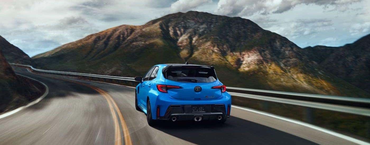 A blue 2024 Toyota GR Corolla is shown from the rear at an angle.