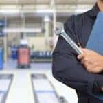 A mechanic is shown holding a wrench and a clipboard.
