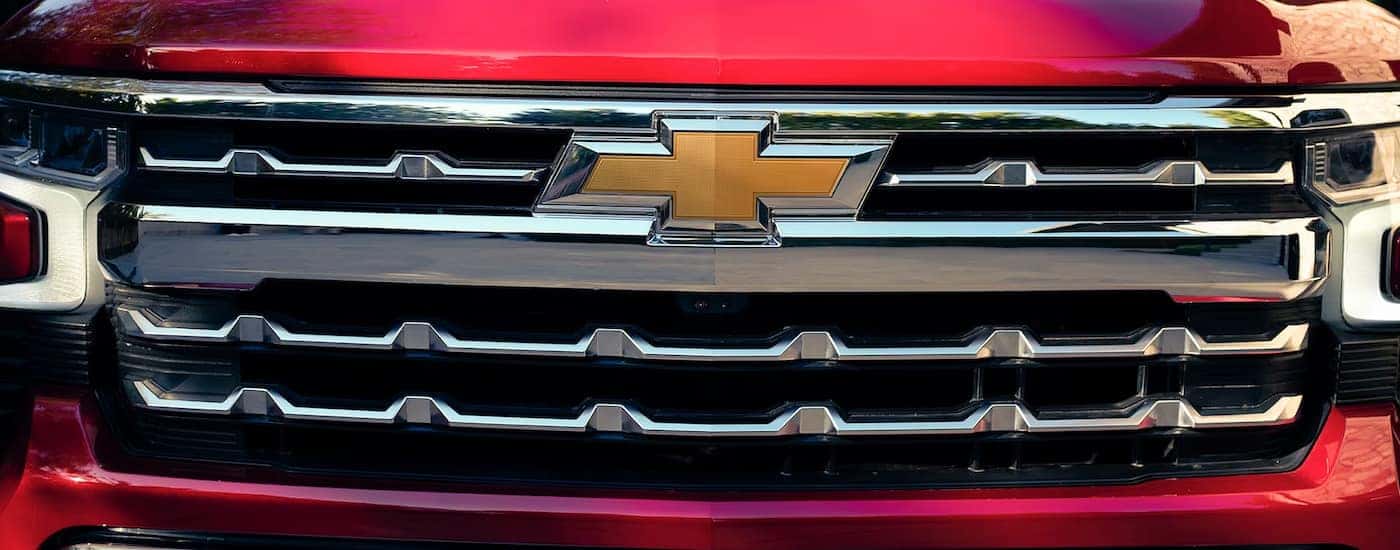 A close up of the grille on a red 2024 Chevy Silverado 1500 LTZ for sale.