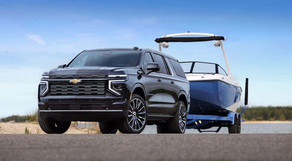 A black 2025 Chevy Suburban High Country is shown from the front at an angle after leaving a Chevy dealer near Jacksboro.
