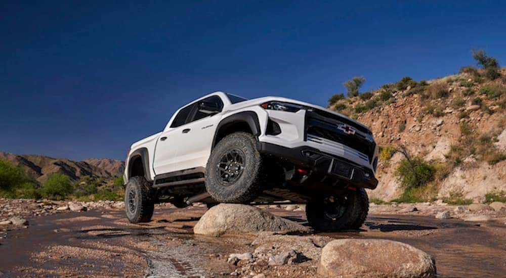 A white 2024 Chevy Colorado ZR2 Bison is shown from the front at an angle after leaving a dealer that has a Chevy Colorado for sale. 