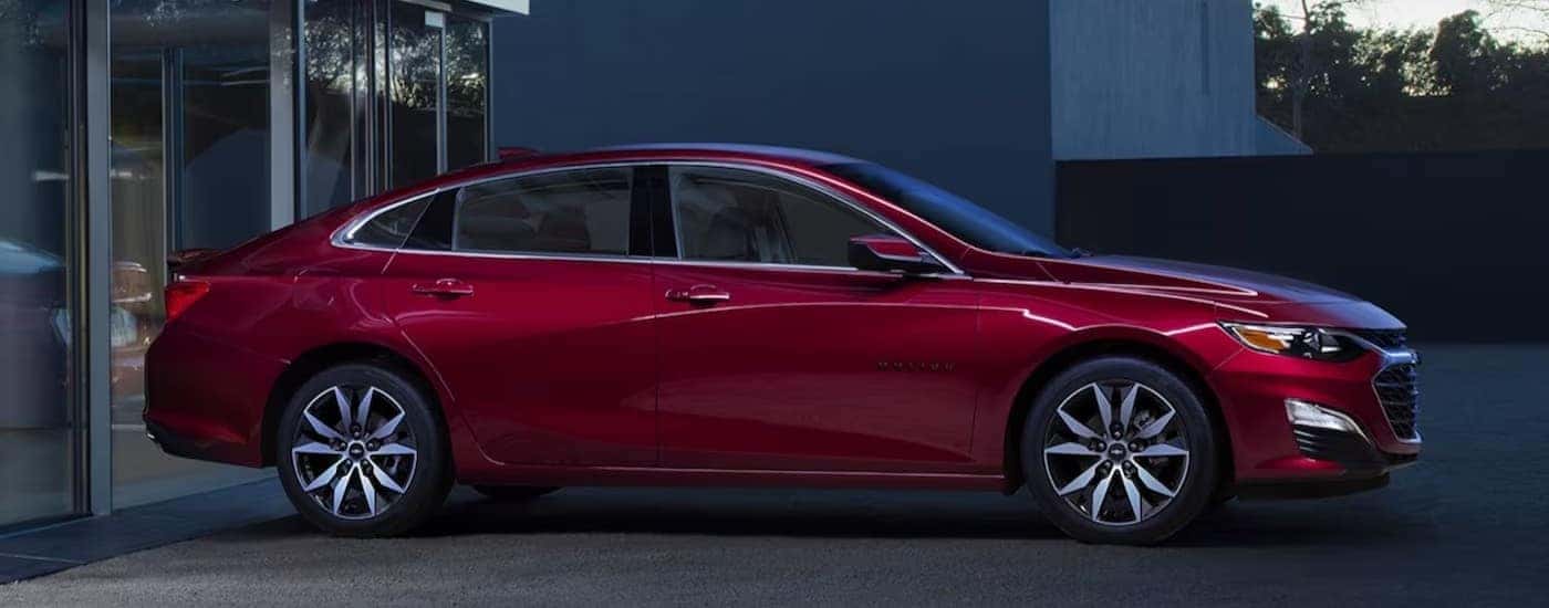 A red 2024 Chevy Malibu parked after visiting a used car dealer.