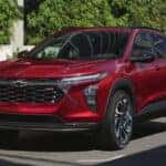 A red 2025 Chevy Trax RS driving to a Chevy dealer near Morristown.