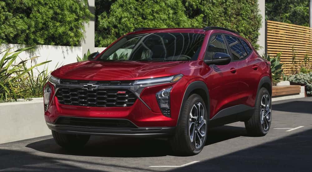 A red 2025 Chevy Trax RS driving to a Chevy dealer near Morristown.