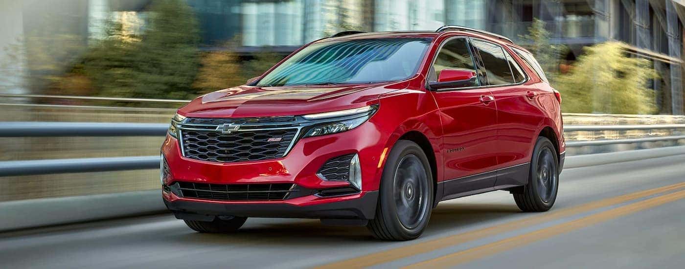 A red 2024 Chevy Equinox RS is shown from the front at an angle after leaving a Chevy dealer near Powell.