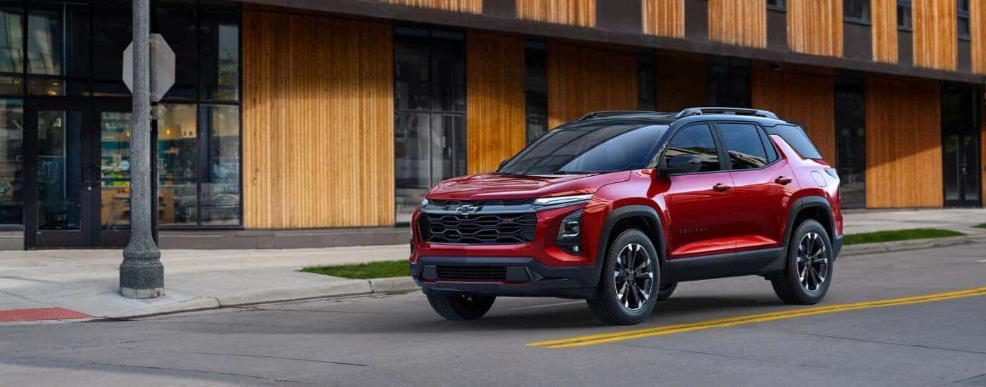 A red 2025 Chevy Equinox angled left and driving.