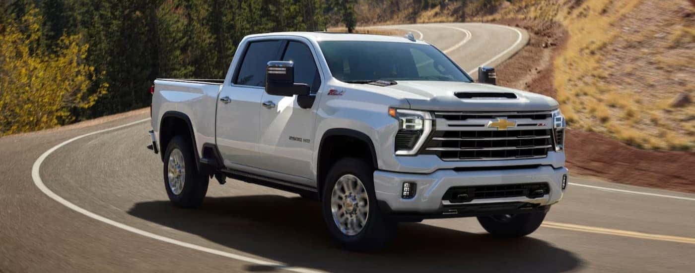 A white 2025 Chevy Silverado 2500 for sale near Knoxville driving on a highway.