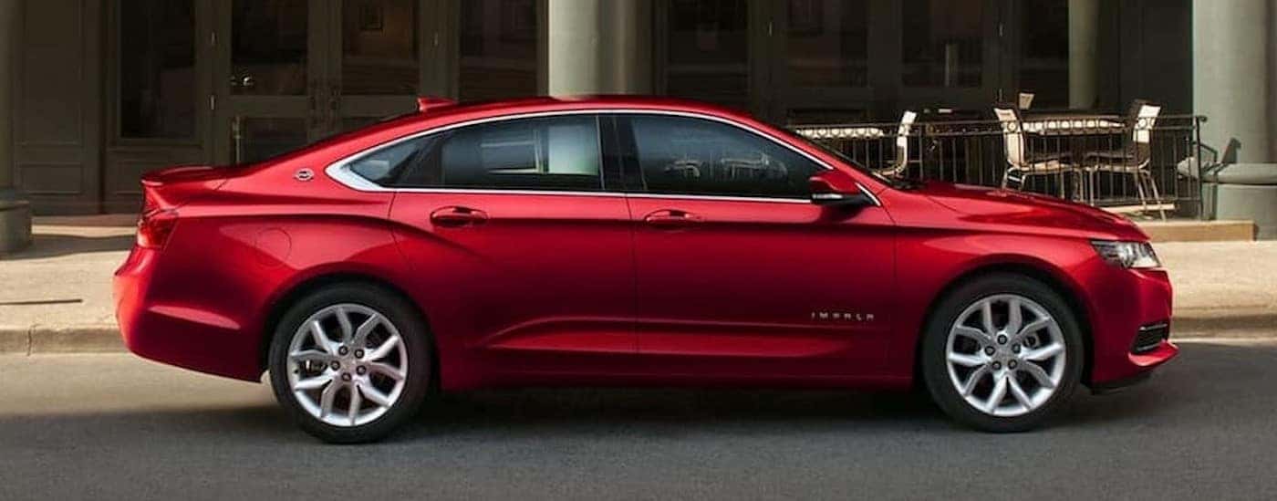 A red 2020 Chevy Impala parked in a city.