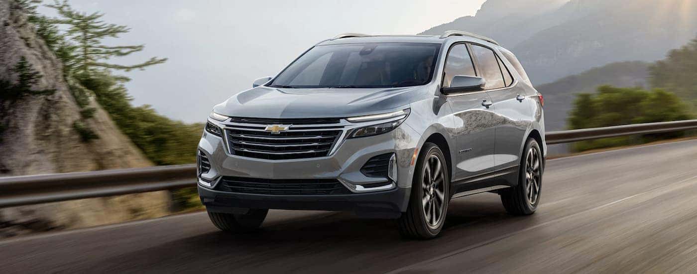 Silver 2023 Chevy Equinox driving on a mountain highway