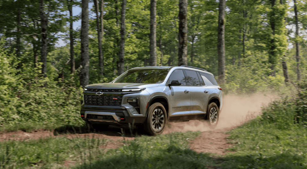 Silver 2026 Chevy Traverse RS driving down a trail