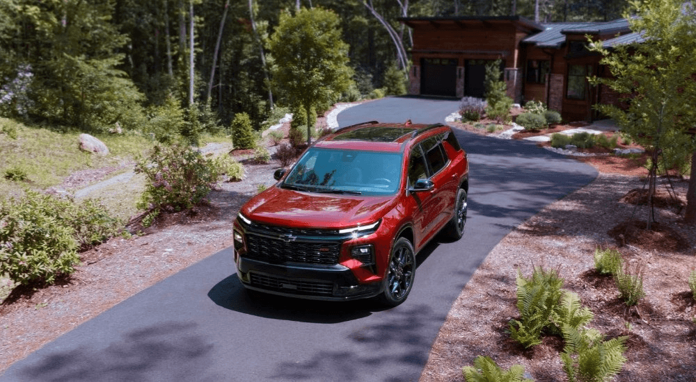 Red 2026 Chevy Traverse driving down a driveway