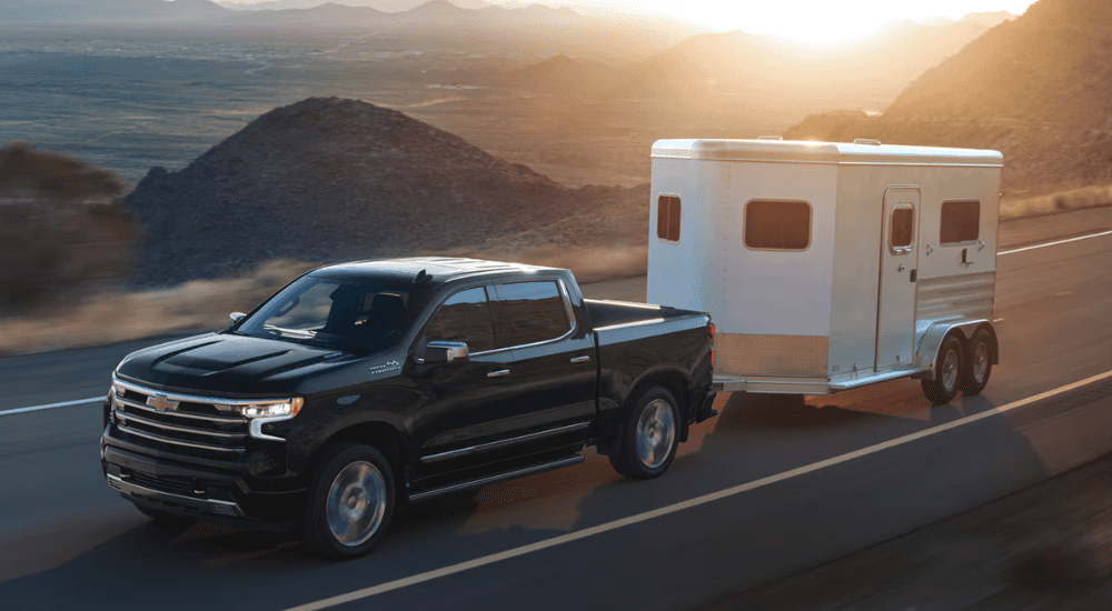 Black 2026 chevy Silverado 1500 towing a horse trailer