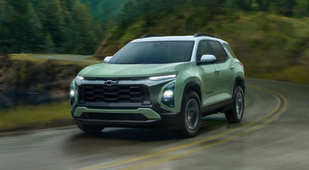 Green 2026 Chevy Equinox driving around a bend.
