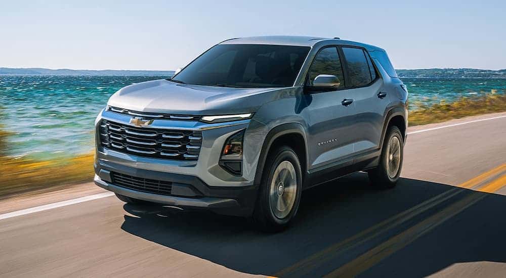 Silver 2026 Chevy Equinox driving down a road.