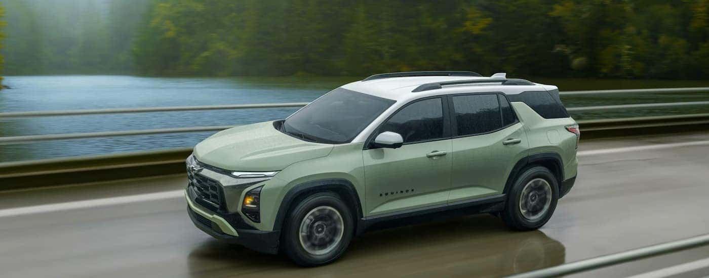 A green 2026 Chevy Equinox ACTIV driving on a highway