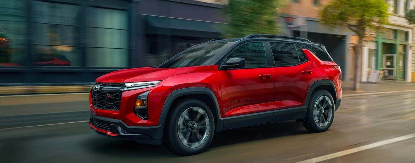 A red 2026 Chevy Equinox RS driving in a city