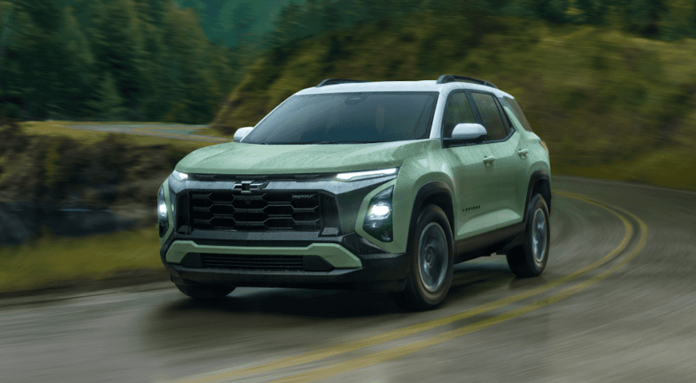 Green 2026 Chevy Equinox ACTIV driving down a road.