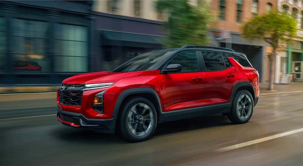 Red 2026 Chevy Equinox RS driving down a street.