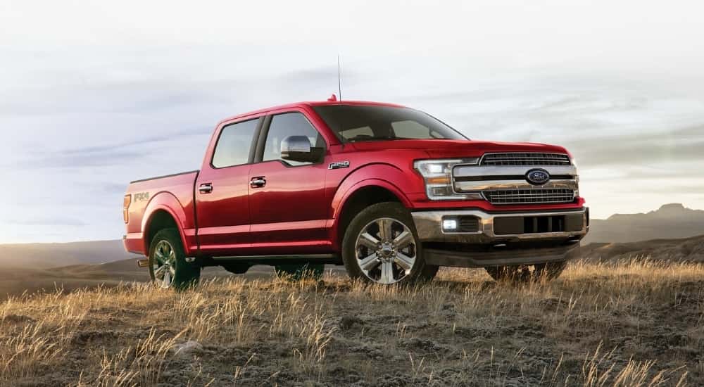 A red 2019 Ford F-150 Lariat parked in a field.