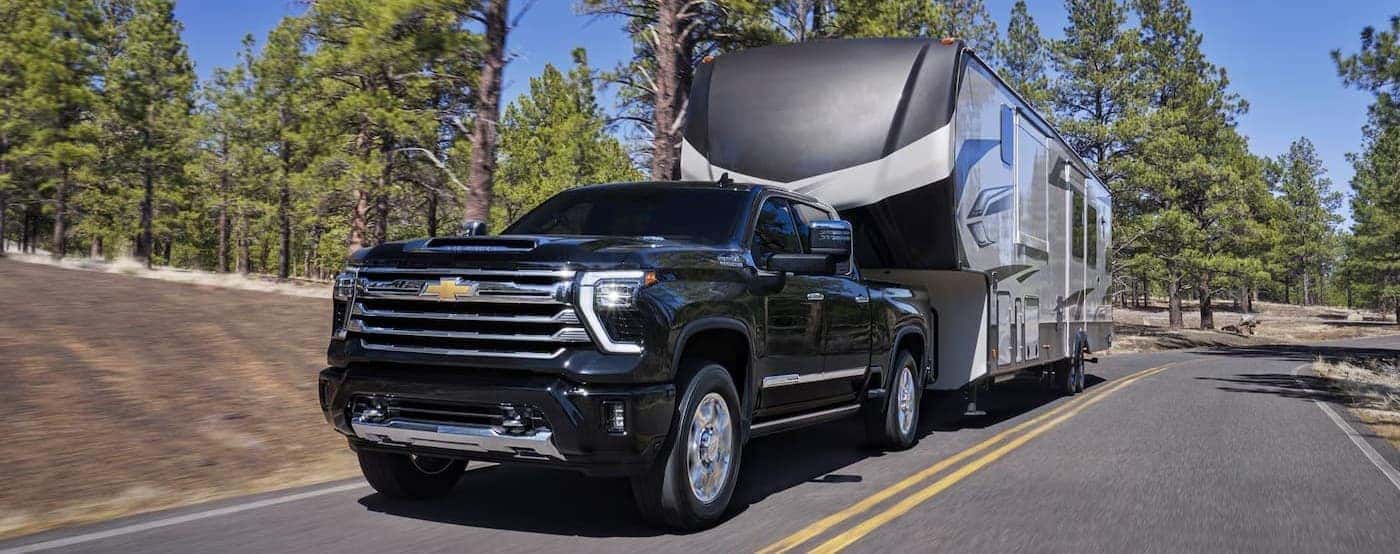 A black Chevy Silverado 2500 HD towing a trailer.
