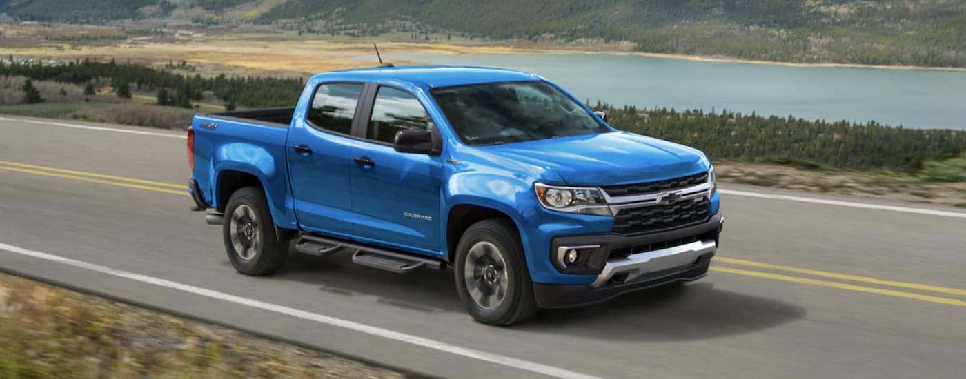 A blue 2022 Chevy Colorado Z71 driving near a lake