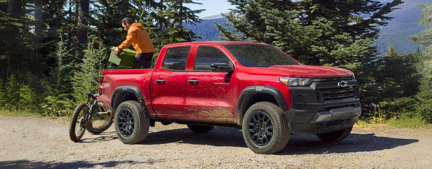 A red 2023 Chevy Colorado Trail Boss parked on a dirt road.