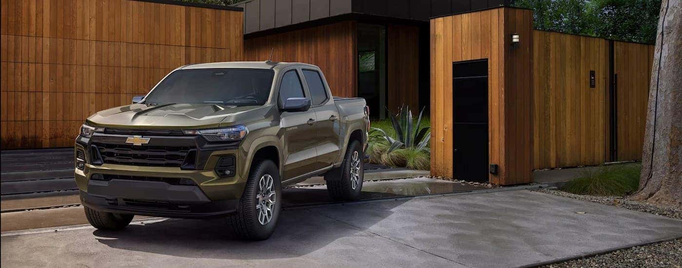 A green 2025 Chevy Colorado parked near a house.