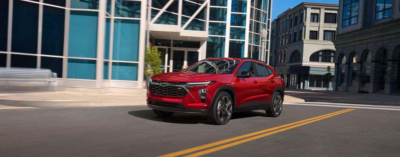 Red 2026 Chevy Trax driving down a road.