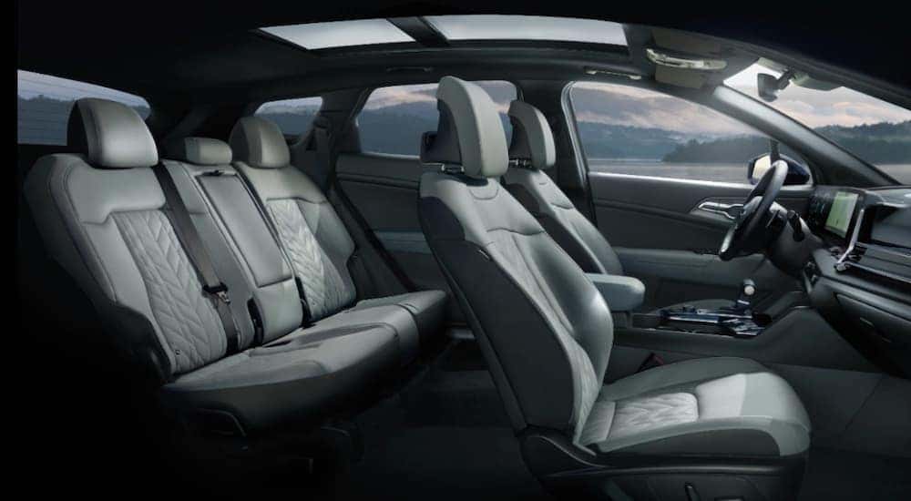 The grey front and rear seats inside a 2024 Kia Sportage for sale at a Kia dealer.
